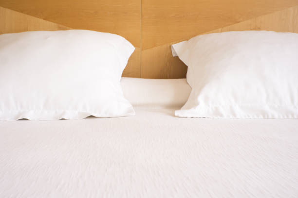 istock Pillows with white covers on luxury hotel king size bed. No people 1267865924