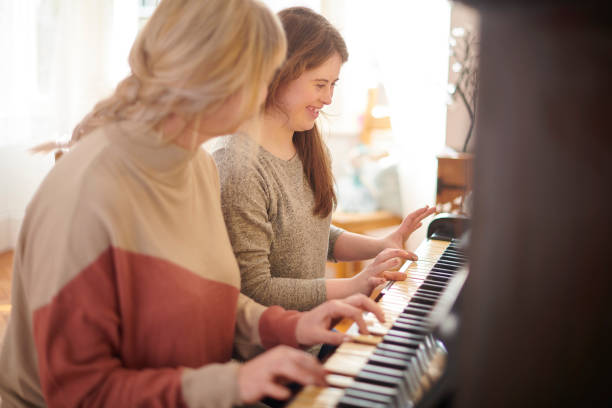 istock mother and daughter playing piano 1267866224