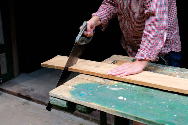 istock Craftswoman with hand saw cutting board. DIY, woodwork concept. 1267868281