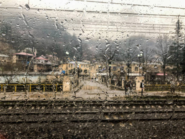 vue du village dans les montagnes depuis la fenêtre du train. - looking at view railroad station street railroad track photos et images de collection