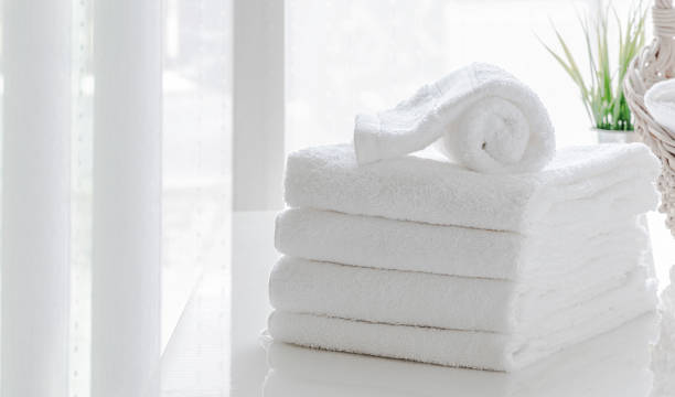 istock Clean white towels on white table in white room, copy space. 1267894666
