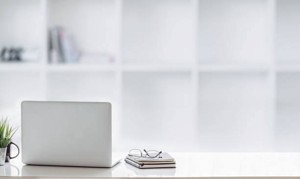 istock Mockup laptop on white top table in white office room. 1267896806