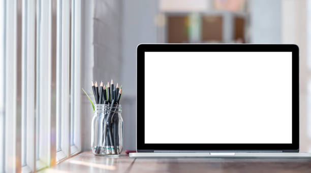 istock Computer Laptop with blank screen on table in contemporary room. Mockup laptop with blank screen for graphic design. 1267901596