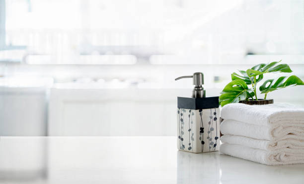 istock Ceramic shampoo, soap bottle and towels on counter over kitchen room background. White top table and copy space. 1267902649