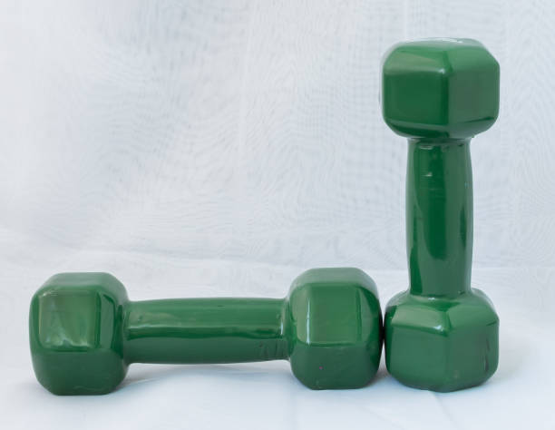 istock Green dumbbells on a white background close-up. 1267906382