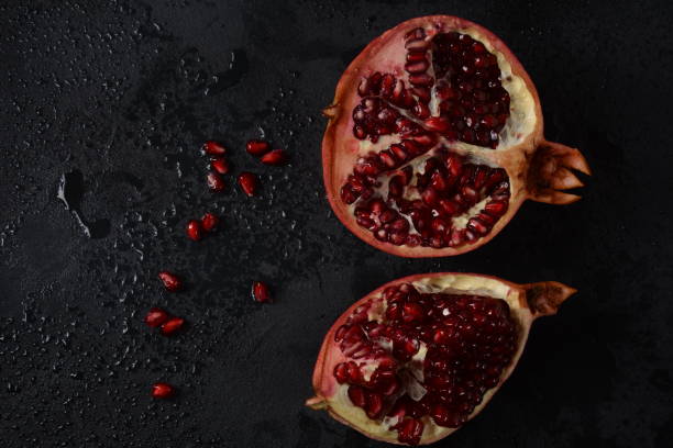 istock Fresh sliced pomegranates. Half pomegranate and pomegranate grains 1267928525