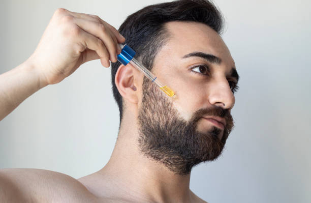 수염 기름을 들고 있는 수염을 기리는 남자 - men stubble beard human hair 뉴스 사진 이미지