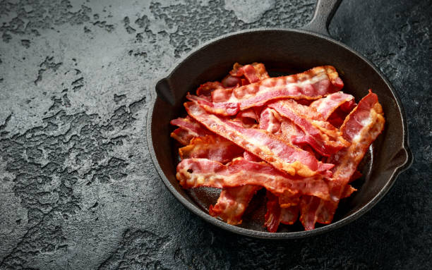 istock Fried crunchy Streaky Bacon pieces in a cast iron skillet 1267929711