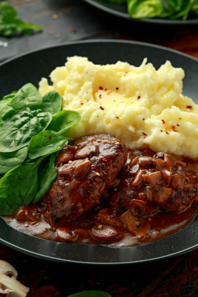 стейк из солсбери с грибным соусом, картофельным пюре и шпинатом - salisbury steak стоковые фото и изображения