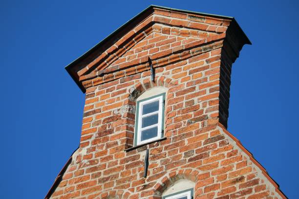 view of the facade of a red brick Sologne house on a sunny summer day with a blue sky in the background