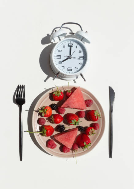 istock Intermittent fasting concept with empty colorful plates. On plate are berries, strawberries, raspberries, blackberries.Time to lose weight , eating control or time to diet concept. 1267936039