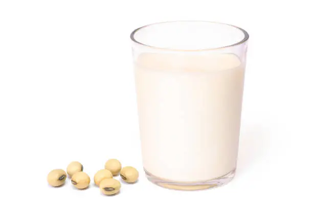 Glass of soymilk and soy beans 
isolated on white background.
