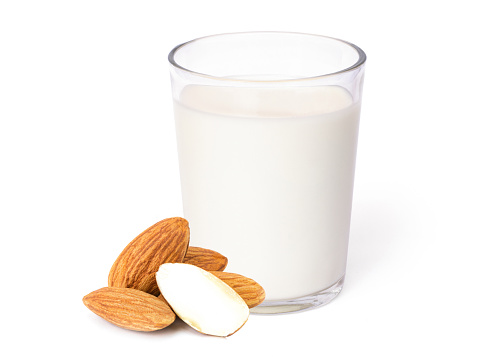 Glass of Almond milk and almond seeds isolated on white background. Healthy drinks concept.