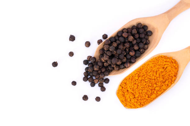 Tumeric and black peppercorn Curcumin powder ( tumeric ground, turmeric, Curcuma ) and black pepper corn in wooden spoon isolated on white background. Health benefits and antioxidant food concept. Top view. Flat lay. black peppercorn photos stock pictures, royalty-free photos & images