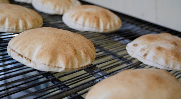 istock Background image of arabic bread produced in a machine.Arabic bread production 1267938975