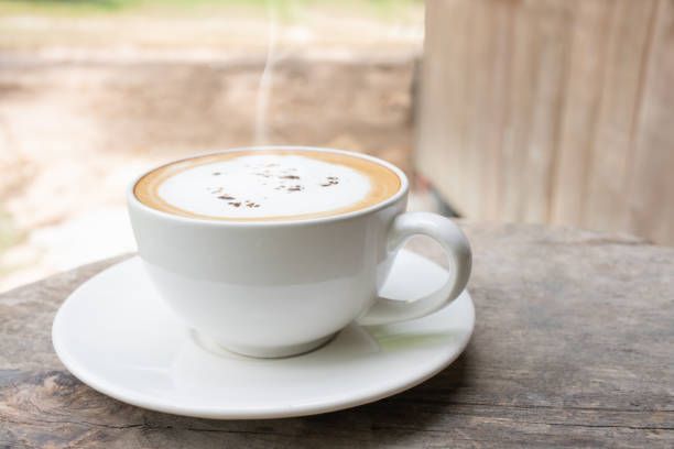 xícara de café de aroma quente na mesa de madeira pela manhã. - starbucks coffee bean editorial - fotografias e filmes do acervo