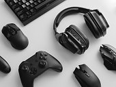 gamer work space concept, top view a gaming gear, mouse, keyboard, joystick, headset, mobile joystick, in ear headphone and mouse pad on black table background.