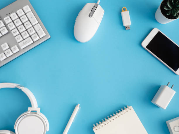 istock top view of office desk table with notebook, plastic plant and keyboard on blue background, graphic designer, Creative Designer concept. 1267943703