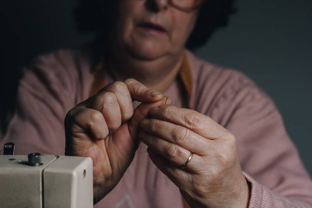 costurera enhebrando una aguja - thimble sewing item close up studio shot fotografías e imágenes de stock