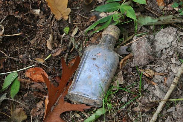 Top view of a broken empty glass bottle on a park floor