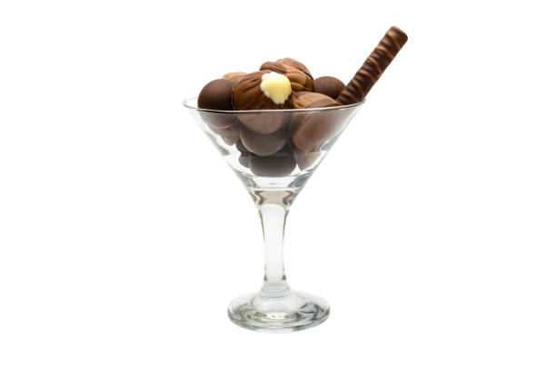 Assortment of chocolates, sweets isolated on white background in glass