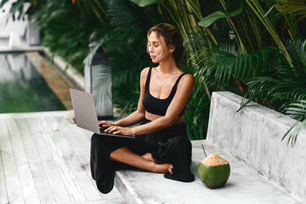 mujer trabajando con laptop junto a la piscina. - swimwear bikini swimming pool red fotografías e imágenes de stock