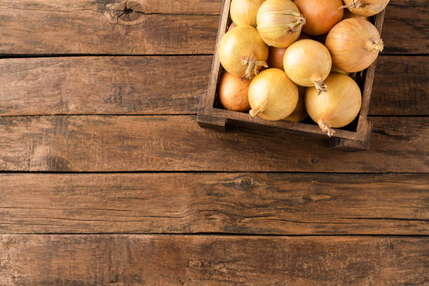 istock Overhead shot of fresh white onions in box on rustic wooden background with copyspace 1267954281
