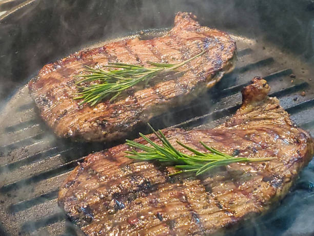 istock cooking rib eye steak with greens in a pan grill 1267958991