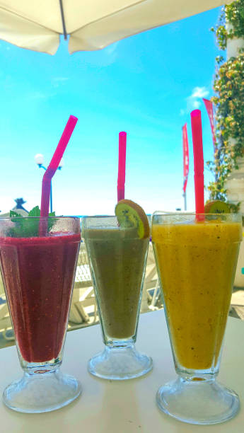 istock smoothies on blue sky background, 3 smoothies in glass glasses 1267967870