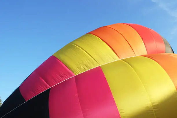 Preparation of a multicolored hot air balloon closeup on blue sky
