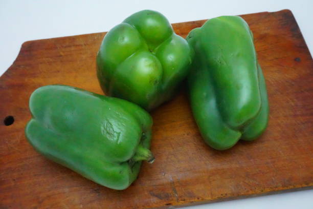 three whole green peppers, chili peppers, blackberry, chilli, on wooden boards, gastronomic seasoning, stock photo