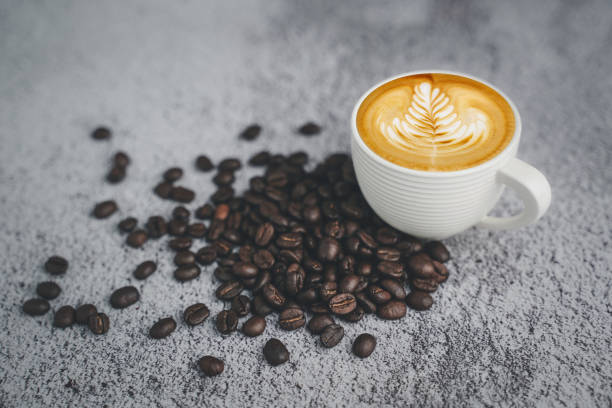 istock hot espresso and coffee bean on white concrete table with soft-focus and over light in the background. top view with copyspace for your text 1267992143