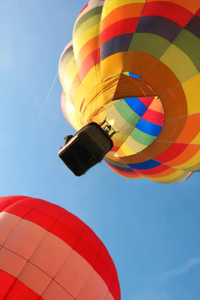 hot air balloon in flight with its basket seen from below