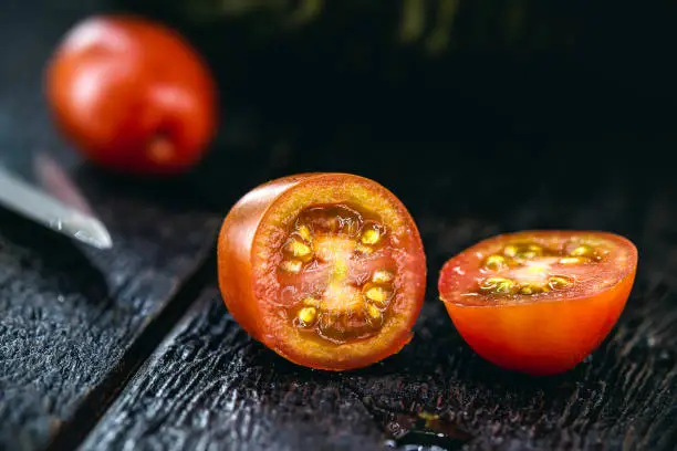 sliced "u200b"u200bBrazilian tomato, detail in macro photograph of culinary ingredient, on rustic wooden background