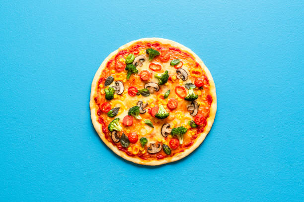 istock Pizza primavera on a blue table, top view. Vegetarian pizza isolated on a colored background. 1267996753