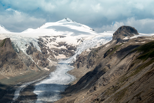 View of the Pasterze Glacier (Johannisberg in the distance) as seen from the Grossglockner Hochalpstrasse at the Kaiser-Franz-Josefs-Höhe.\nThe Grossglockner is Austria’s highest mountain and centrepiece of the High Tauern National Park. The “black mountain” rises 3,798 m above a sea of three hundred 3,000 m peaks surrounding it.