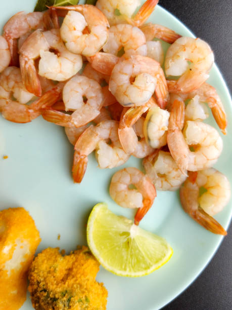 istock Boiled peeled shrimp on a blue plate close-up. Shrimp with lemon 1268000160