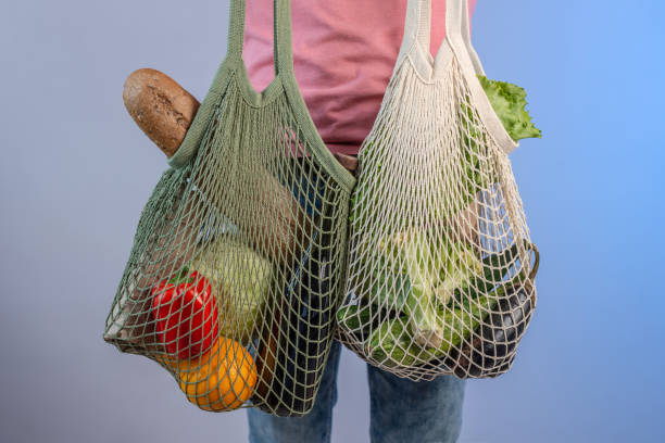 istock Modern young man is holding a string bags with purchases. Concept of eco-friendly behavior, the use of reusable bags and concern for the environment 1268008191