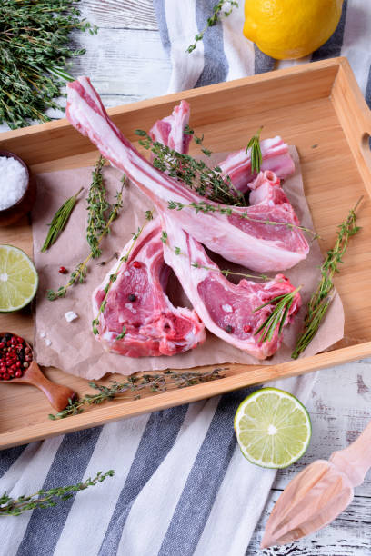 Raw lamb ribs, spices and herbs on parchment