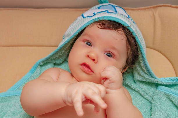 istock Portrait of a baby in a towel lying on the changing table. 1268020002