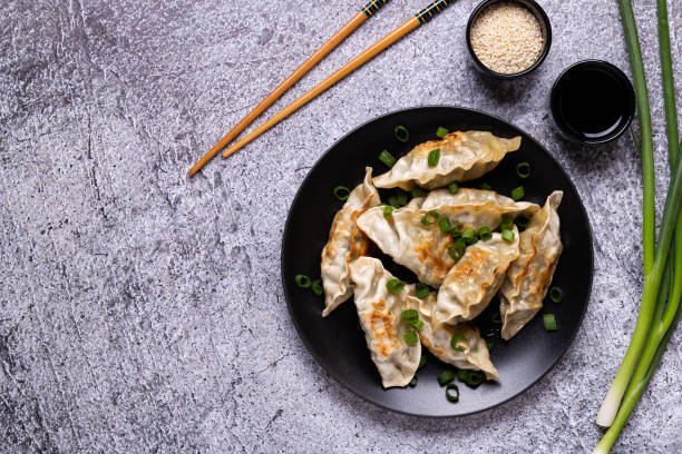 istock Fried dumplings Gyoza on a plate on a gray concrete background 1268020990
