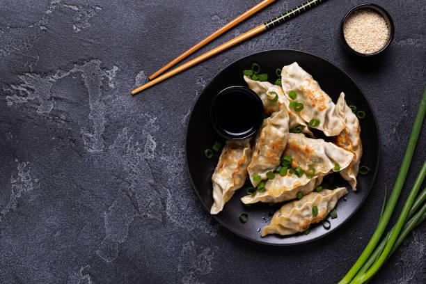Fried dumplings Gyoza on a plate on a gray concrete background Fried dumplings Gyoza on a plate on a gray concrete background, top view fried photos stock pictures, royalty-free photos & images
