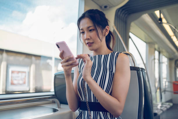 istock Young woman using mobile phone while commuting with the subway in the city 1268022975