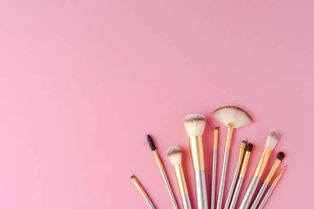 Collection of golden makeup brushes with copyspace