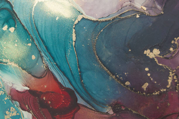 istock High resolution luxury abstract fluid art painting in alcohol ink technique, mixture of blue, green and purple paints. Imitation of marble stone cut, glowing golden veins. Tender and dreamy design. 1268028637