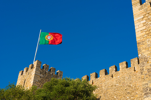Lisboa, Portugal - July 24 2016: Flag of Portugal waving over Castelo de São Jorge.