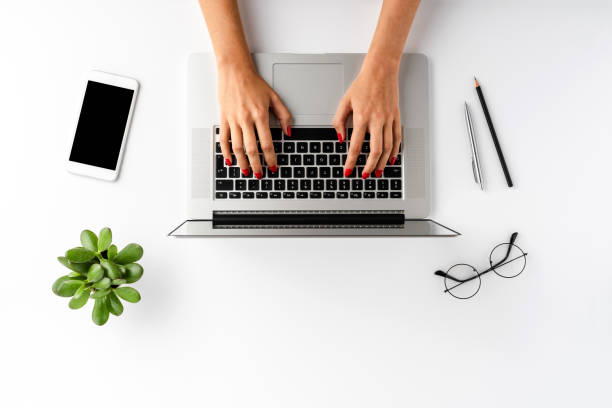 istock Female hands using laptop on white background with accessories. Office desktop. Top view 1268028841
