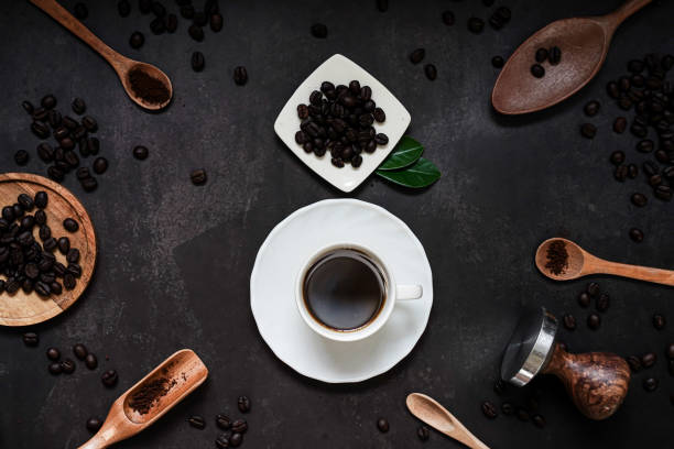 cup of coffee and coffee composition on black background. copy space. top view. flat lay. - napkin black blank ideas imagens e fotografias de stock