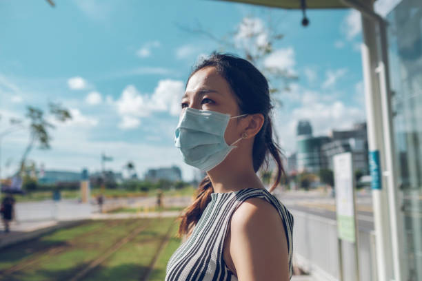 istock Asian woman with protective face mask commuting in the city 1268029664