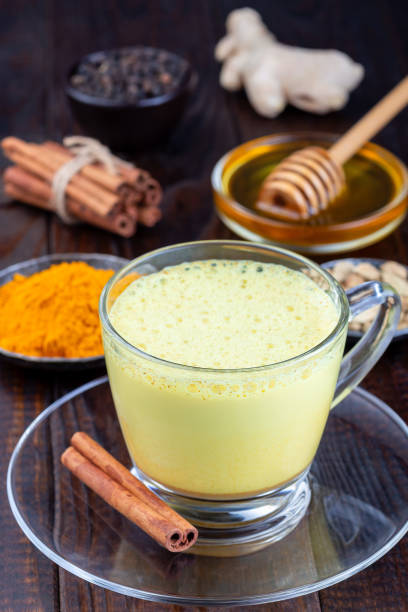 istock Moon milk with turmeric in glass cup, ingredients on background, vertical 1268032810